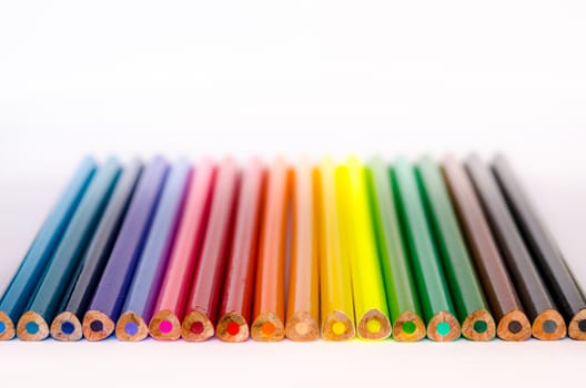 Detail of colorful pencils in a row on white background