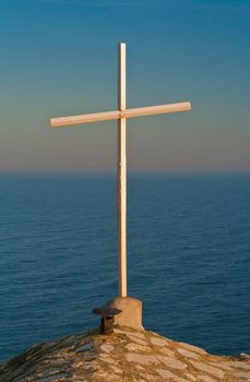 An old concrete cross over a clear blue sky