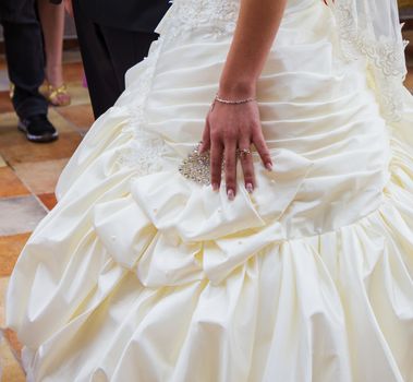 Wedding day. Hand of bride with a wedding ring on her dress