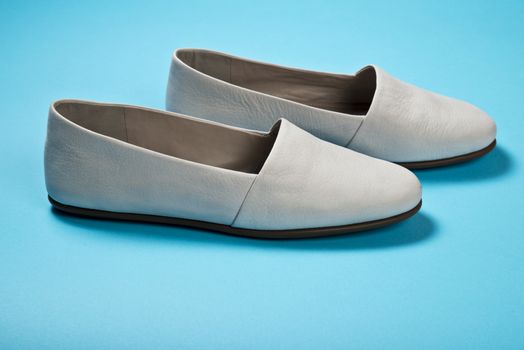 Woman casual gray leather shoes on blue