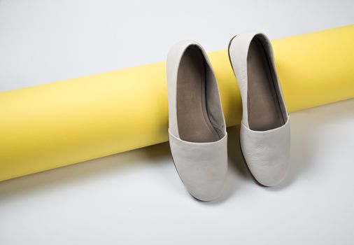 Woman casual gray leather shoes on yellow
