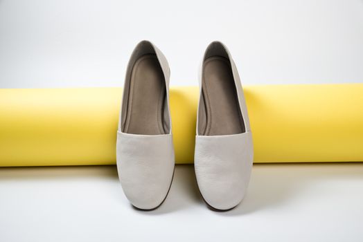 Woman casual gray leather shoes on yellow
