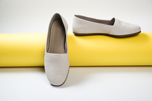 Woman casual gray leather shoes on yellow
