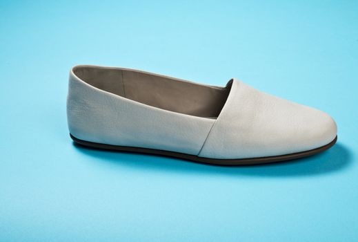 Woman casual gray leather shoes on blue