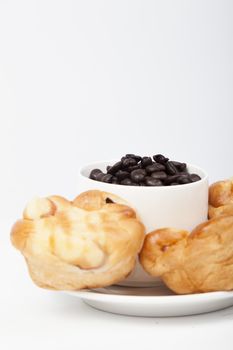 Roasted coffee beans in a glass Bread on plate On a white background