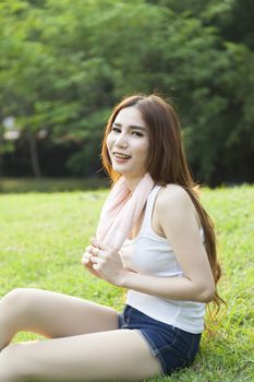 Woman sitting on the grass. After jogging in the park.