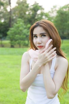 Woman standing rest after jogging. On lawn in the park