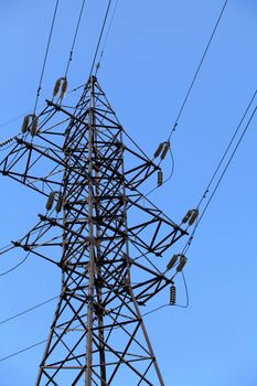 Power lines and electricity pylon  against blue sky