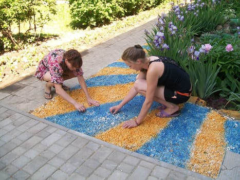 Children draw on the asphalt with crayons