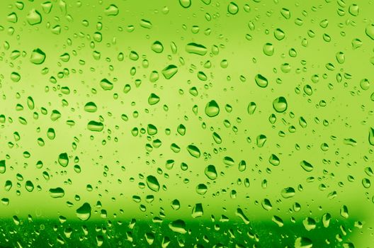 Water droplets on the glass with a colored background. Drops of water.