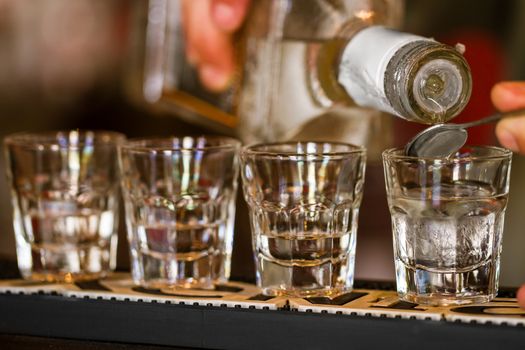 Barman make alcoholic shots in nightclub