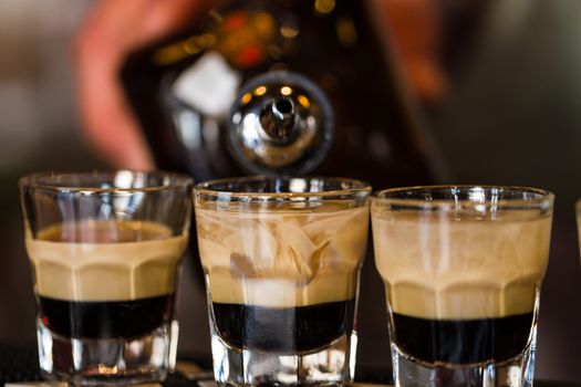 Barman make alcoholic shots with rum and liquor in nightclub