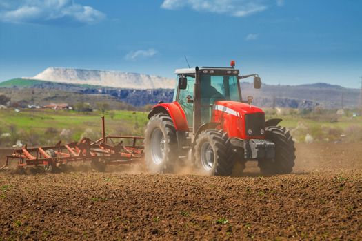 Brand new red tractor on the field working