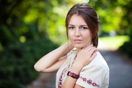 Portrait of young beautiful woman in summer park