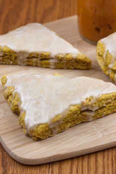 Fresh pumpkin scones with a sweet and spiced glaze on top.