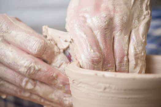 Hands of a potter, creating an earthen jar on the circle