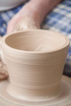 Hands of a potter, creating an earthen jar on the circle