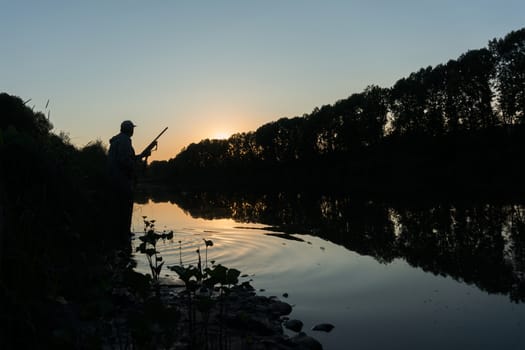 Silhouette of the hunter on a background of a morning dawn