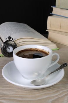 freshly brewed cup of fragrant coffee on a table among books