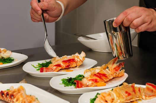Decorating of prepared lobsters on plates, pouring the foam sauce