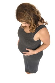 pregnant woman holding her hands on her belly in heart shape