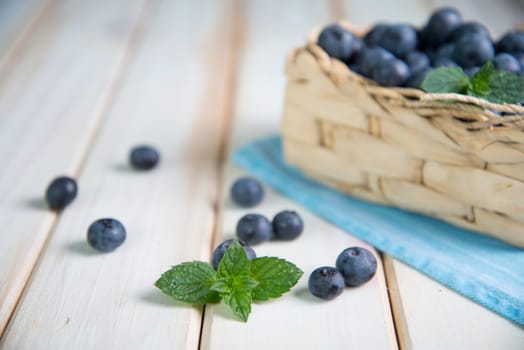 Fresh organic blueberries in basket  on white background retro kitchen table
