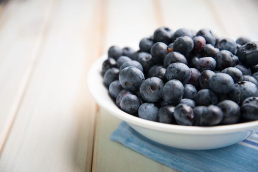 fresh organic blueberries on plate over white background retro kitchen table