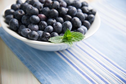 fresh organic blueberries on plate over white background retro kitchen table