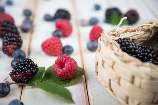 fresh organic berrys fruits in basket on white background retro style wooden table