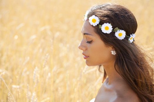 Beautiful young woman in a wheat golden field