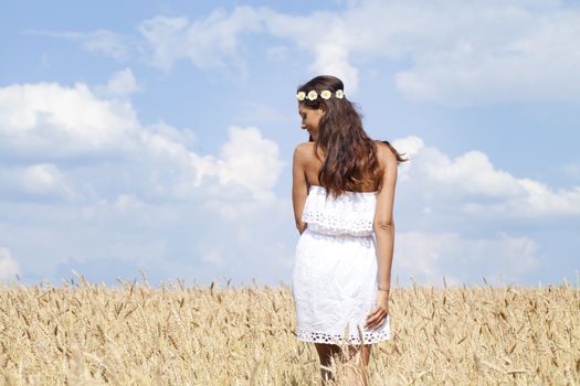 Beautiful young woman in a wheat golden field