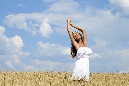 Beautiful young woman in a wheat golden field