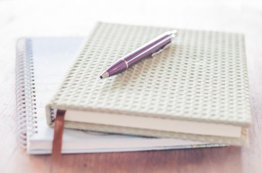 Pen and two of notebooks on wooden table, stock photo