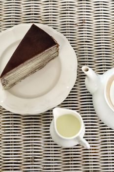 Tea with chocolate crape cake on weave texture