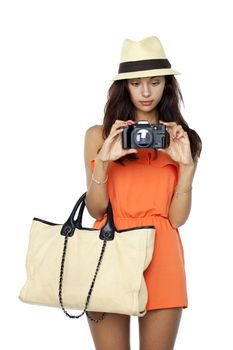 Happy young woman using a camera to take photo, isolated on white