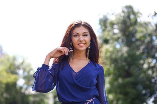 Beautiful young woman walking on the summer park