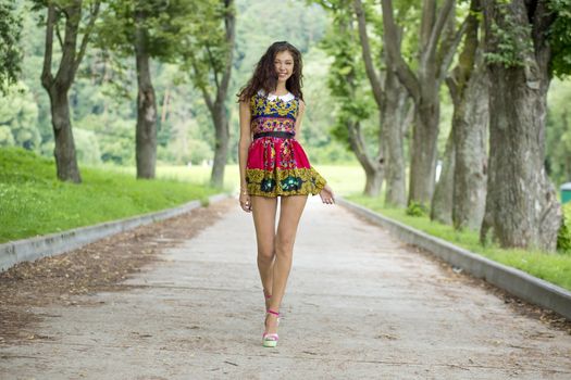 Full growth, beautiful young woman in color dress