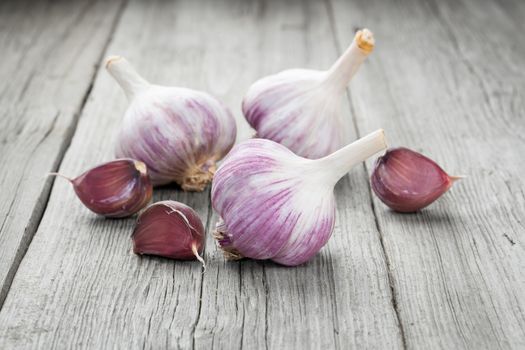 Organic garlic whole and cloves on the wooden background