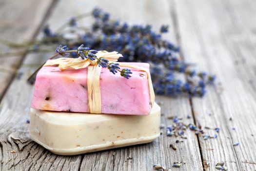 Natural handmade lavender soap and fresh lavender flowers on wooden background