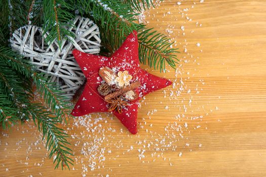 stitched red Christmas star with spices, with decoration, on wood background,