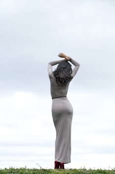 Full growth, beautiful young woman in sexy long gray dress