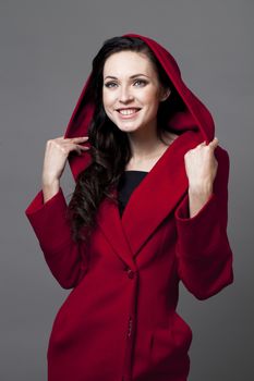 Beautiful young woman in a red coat with hood