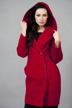 Beautiful young woman in a red coat with hood