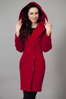 Beautiful young woman in a red coat with hood