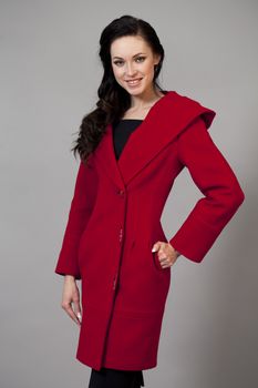 Beautiful young woman in a red coat with hood