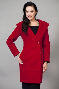 Beautiful young woman in a red coat with hood