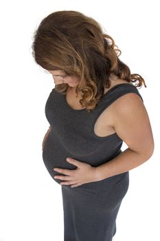 adult pregnant woman holding her hands on her belly looking down