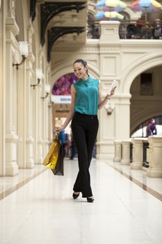 Happy young woman walking in the shop