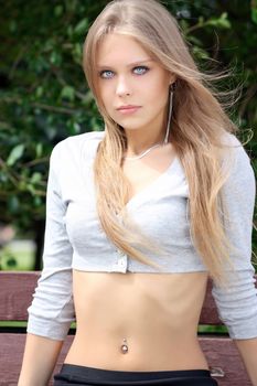 Portrait of blonde young woman in summer park