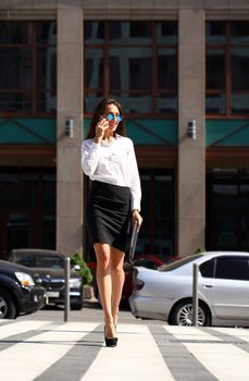 Young beautiful business woman calling by phone
